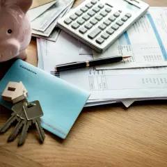 Calculadora, hucha, llaves y facturas sobre una mesa. ¿Qué hipoteca me puedo permitir?