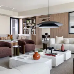 Espacio moderno con sofás modulares, sillones terracota y mesas de centro de mármol, ideal para un flex living.