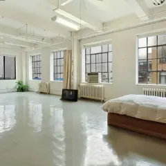 Espacio diáfano con camas y cortinas, ideal para un cambio de uso de vivienda a local.