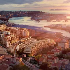 Vista aérea de un moderno complejo de edificios junto a un puerto, con islas al fondo. Un ejemplo de las mejores ciudades para vivir en España.