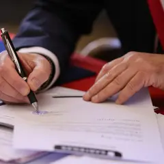 Mano firmando un documento oficial. El **valor pericial** de este acto es la validación de un acuerdo o testimonio.