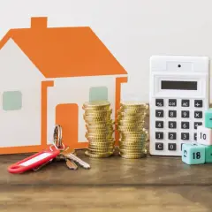 Casa naranja, llaves, monedas y calculadora. Los dados con números y símbolos matemáticos ilustran los gastos a la hora de comprar un piso.