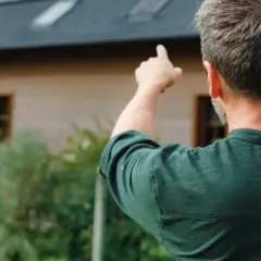 Padre e hija contemplan su futuro hogar. El padre señala el terreno, soñando con las hipotecas autopromotor que harán realidad su casa ideal.