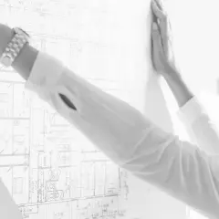 Mujer revisa un plano detallado, parte de un levantamiento de planos para un proyecto arquitectónico.