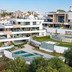 Modernos tipos de casas con piscinas en cascada y terrazas amplias, rodeadas de vegetación y vistas al mar.