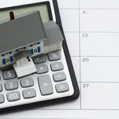 Casa en calculadora y calendario. Planifica tu hipoteca sin aval, calculando cada paso.