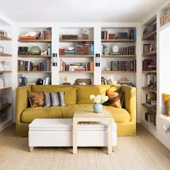 Sofá amarillo y estanterías llenas de libros, una **obra menor** de decoración acogedora.
