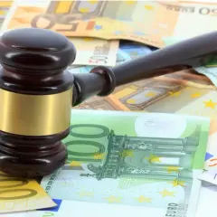Martillo de juez sobre billetes de euros, simbolizando los gastos de notaría en una compraventa de vivienda.