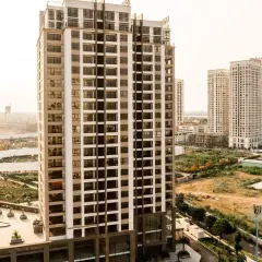 Edificios modernos se alzan sobre un **terreno urbano no consolidado**, con vegetación y construcciones en proceso.