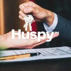 Manos intercambiando llaves sobre un contrato. Las opiniones sobre Huspy son positivas, facilitando transacciones inmobiliarias.