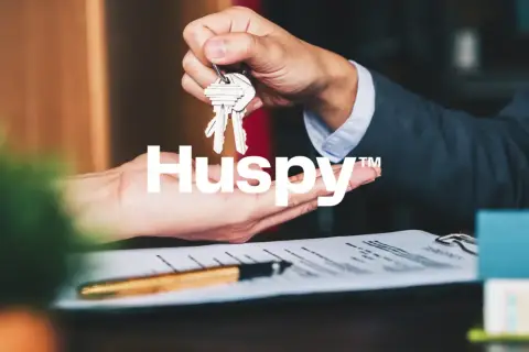 Manos intercambiando llaves sobre un contrato. Las opiniones sobre Huspy son positivas, facilitando transacciones inmobiliarias.