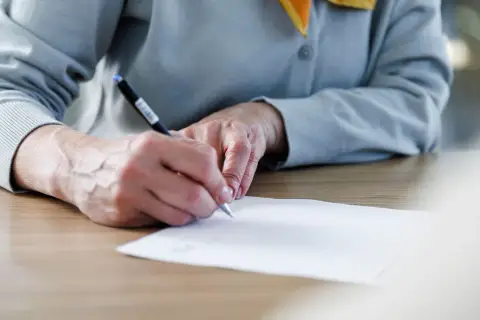Manos firmando un documento importante, un momento clave donde se firma la fe.
