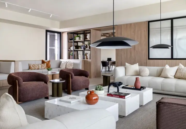 Espacio moderno con sofás modulares, sillones terracota y mesas de centro de mármol, ideal para un flex living.
