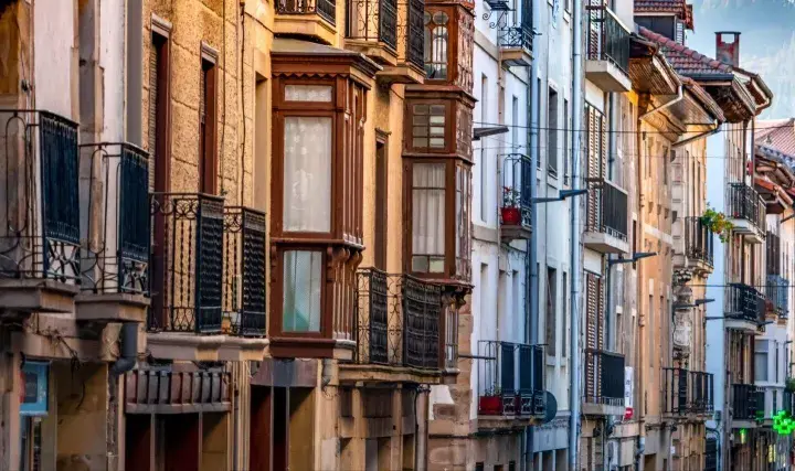 Edificios antiguos con balcones de hierro forjado y ventanales que evocan un caudal hereditario de historia y arquitectura.