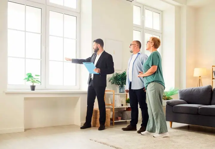 Agente inmobiliario muestra a una pareja una vivienda, explicando la **validez de la tasación de la vivienda** y sus características.