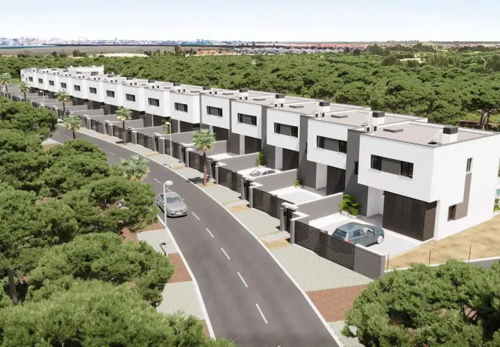 Una hilera de modernos chalets pareados blancos y grises, rodeados de pinos, con una carretera y coches.
