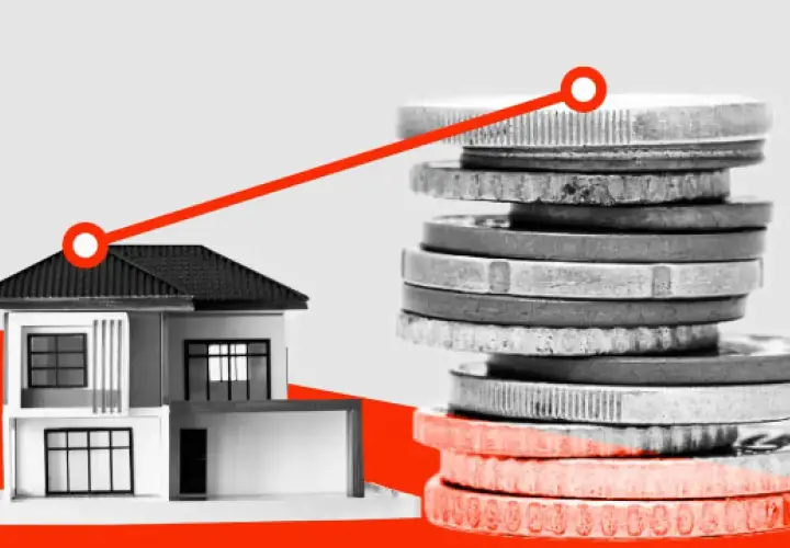 Casa y pila de monedas con línea ascendente. El impuesto segunda vivienda puede afectar tus finanzas.