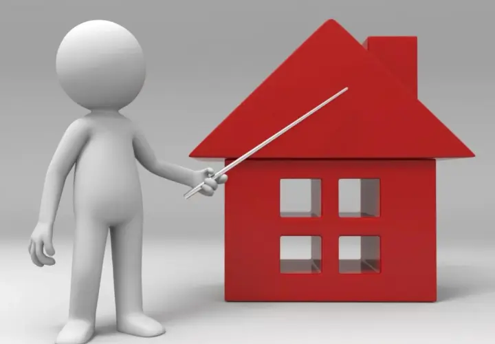 Un muñeco blanco señala una casa roja. Un piso es un inmueble, y esta casa representa uno.