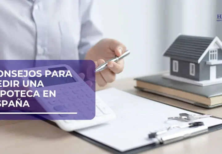 Calculadora, casa modelo y llaves sobre documentos, sugiriendo consejos para la ley hipotecaria en España.