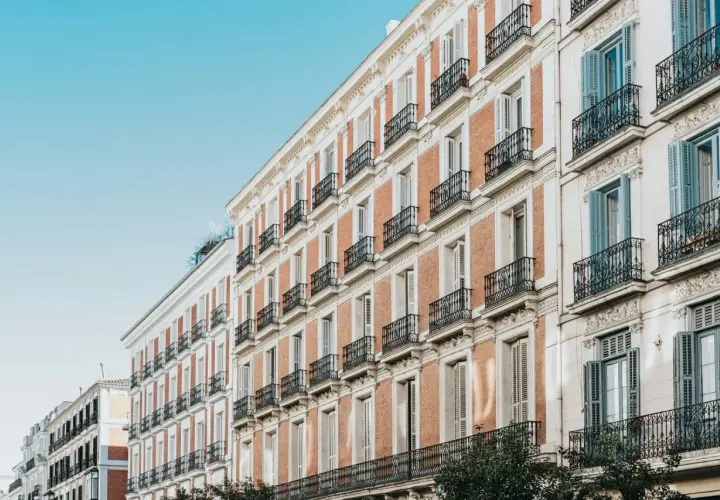 Edificios de ladrillo y piedra con balcones de hierro forjado, como se constituye una comunidad de bienes en un edificio histórico.