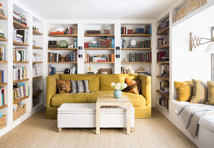 Sofá amarillo y estanterías llenas de libros, una **obra menor** de decoración acogedora.