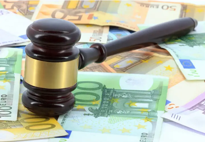 Martillo de juez sobre billetes de euros, simbolizando los gastos de notaría en una compraventa de vivienda.