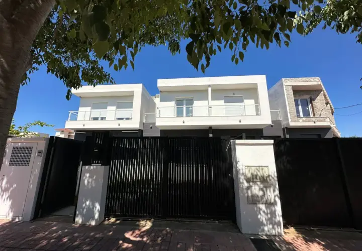 Modern houses behind a black gate. A tasador hipoteca would appreciate the clean lines and potential value.