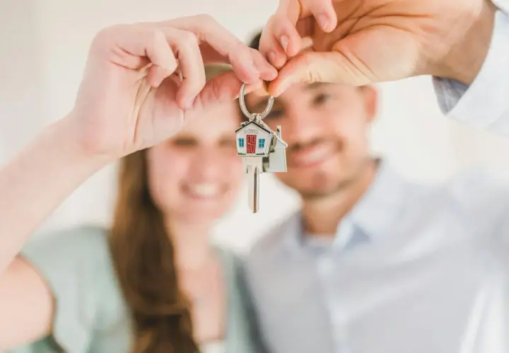 Pareja feliz sosteniendo llaves de casa. ¿Cuánto cobra Tecnocasa por vender un piso?