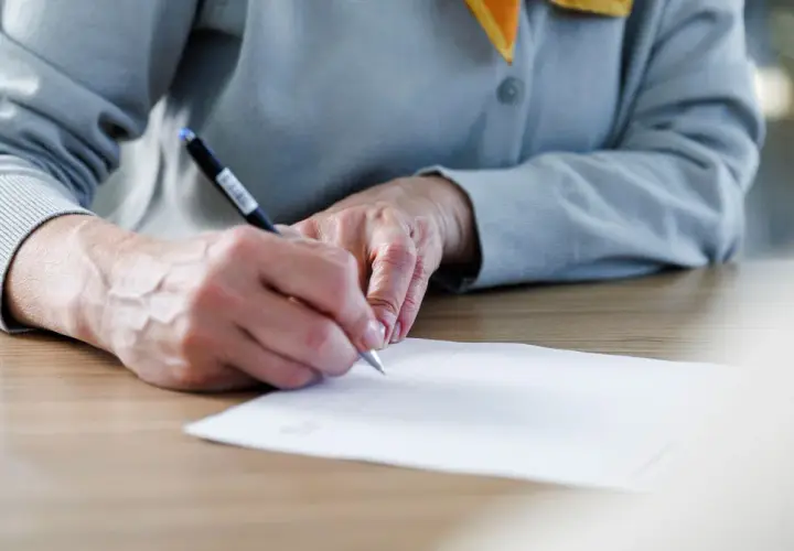 Manos firmando un documento importante, un momento clave donde se firma la fe.