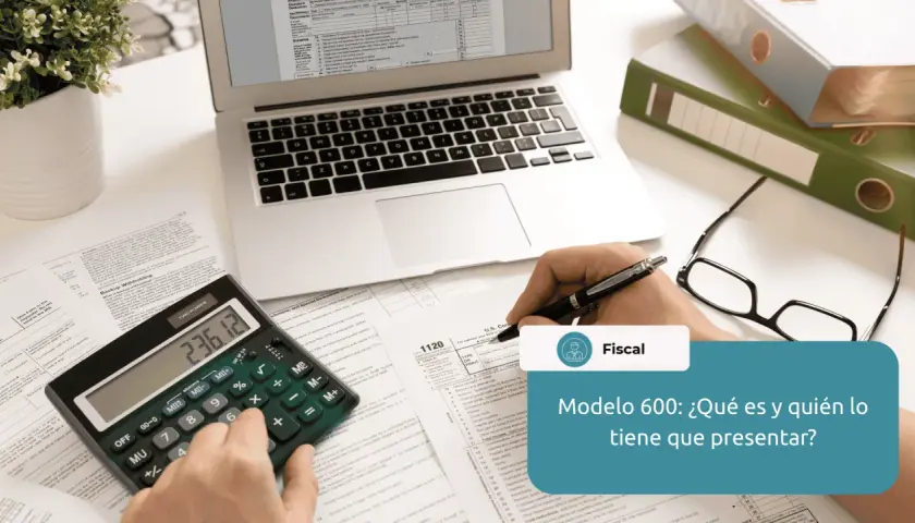 Calculadora, gafas, portátil y documentos fiscales sobre un escritorio.