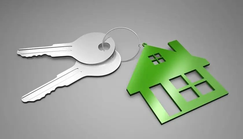 Dos llaves plateadas y un llavero con forma de casa verde. ¿Qué es el aval ico? Es la llave de tu nuevo hogar.