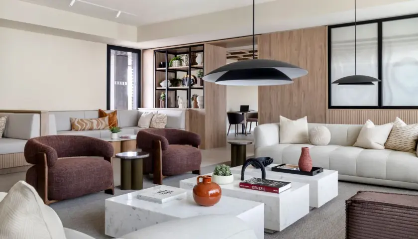 Espacio moderno con sofás modulares, sillones terracota y mesas de centro de mármol, ideal para un flex living.