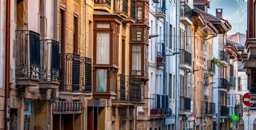 Edificios antiguos con balcones de hierro forjado y ventanales que evocan un caudal hereditario de historia y arquitectura.