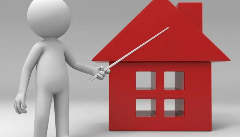 Un muñeco blanco señala una casa roja. Un piso es un inmueble, y esta casa representa uno.