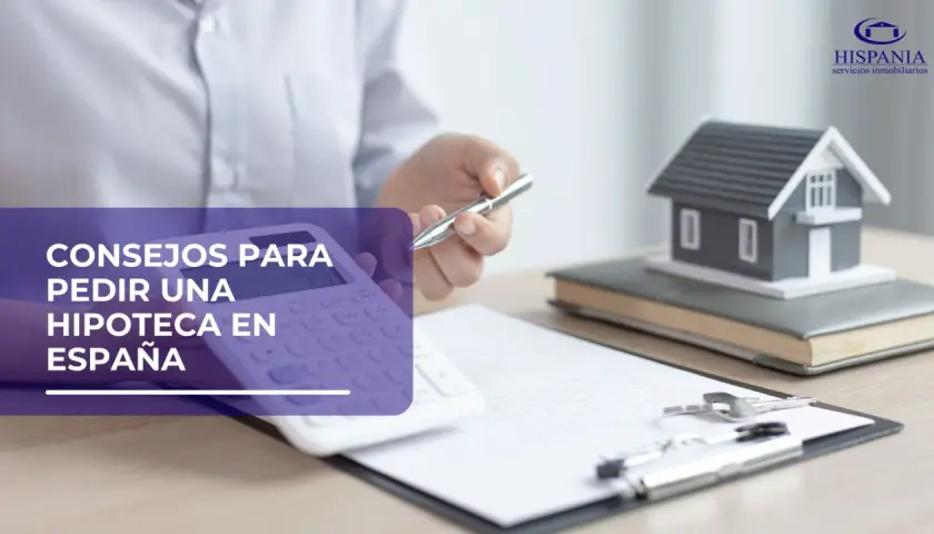 Calculadora, casa modelo y llaves sobre documentos, sugiriendo consejos para la ley hipotecaria en España.