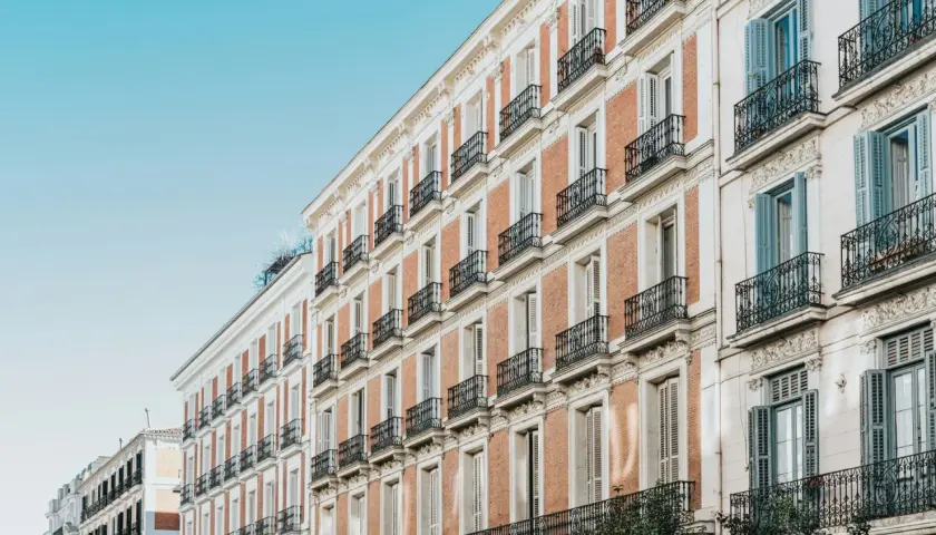 Edificios de ladrillo y piedra con balcones de hierro forjado, como se constituye una comunidad de bienes en un edificio histórico.