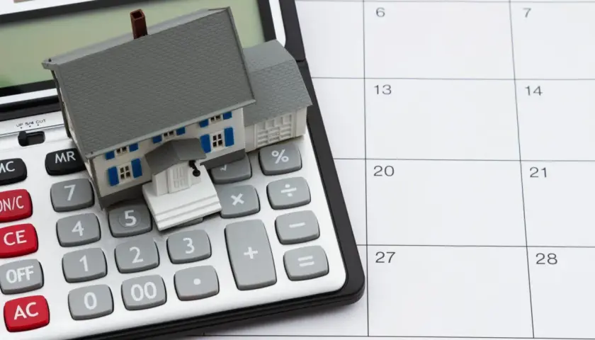 Casa en calculadora y calendario. Planifica tu hipoteca sin aval, calculando cada paso.