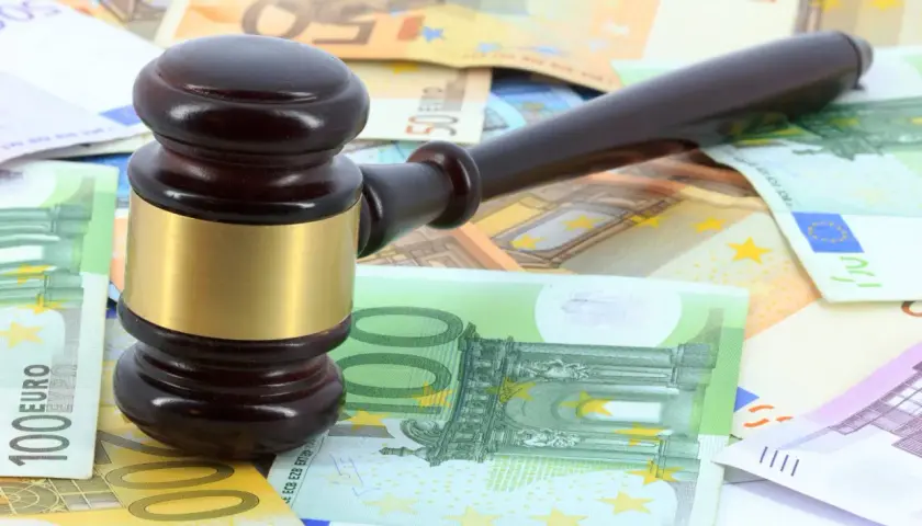 Martillo de juez sobre billetes de euros, simbolizando los gastos de notaría en una compraventa de vivienda.