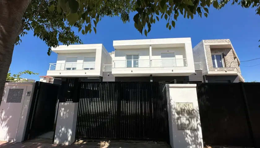 Modern houses behind a black gate. A tasador hipoteca would appreciate the clean lines and potential value.