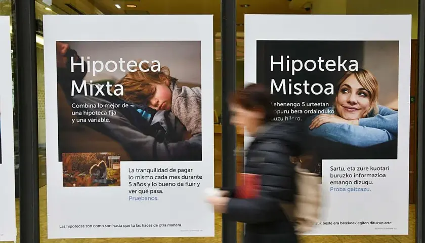 Anuncios de Kutxabank sobre hipotecas mixtas. Un cartel muestra a un niño durmiendo, el otro a una mujer sonriendo.