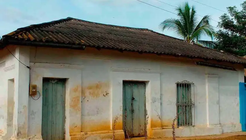 Casa antigua con tejas oscuras, dos puertas verdes y una ventana enrejada. El **precio** de esta **declaración de obra nueva antigua** es negociable.