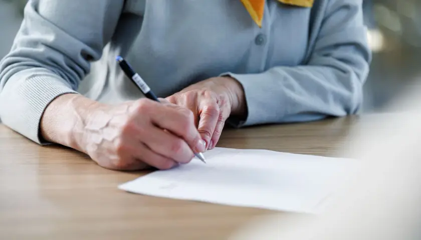 Manos firmando un documento importante, un momento clave donde se firma la fe.