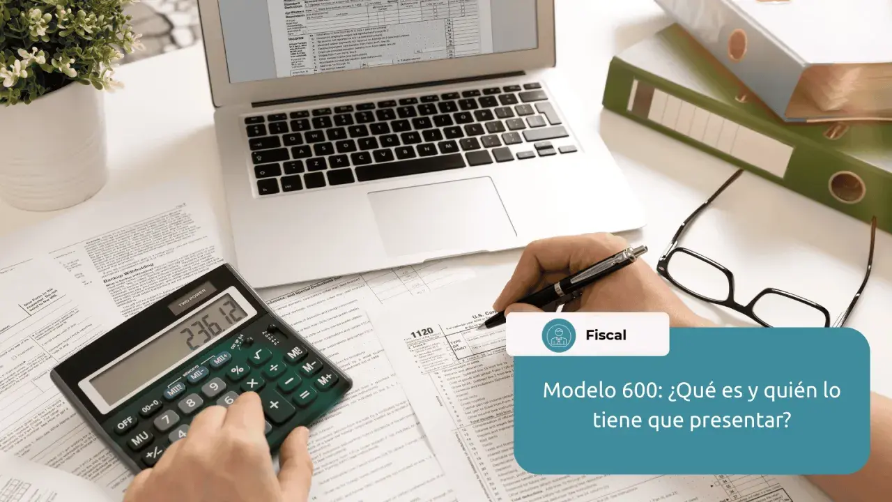 Calculadora, gafas, portátil y documentos fiscales sobre un escritorio.