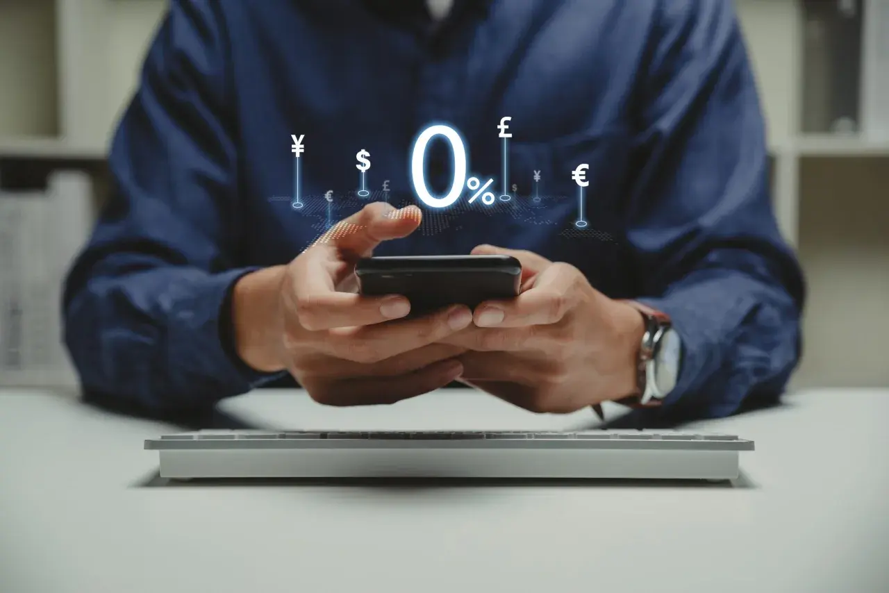 Man using smartphone with 0% interest and currency symbols, ideal for managing comisiones bancarias comunidades de propietarios.