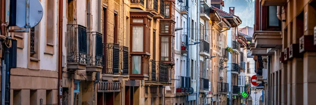 Edificios antiguos con balcones de hierro forjado y ventanales que evocan un caudal hereditario de historia y arquitectura.