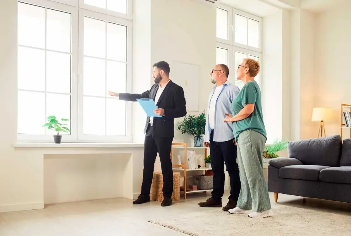 Agente inmobiliario muestra a una pareja una vivienda, explicando la **validez de la tasación de la vivienda** y sus características.
