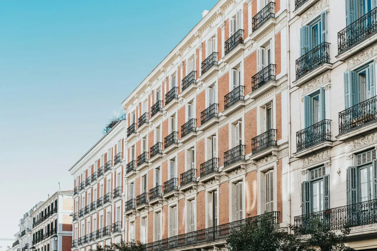 Edificios de ladrillo y piedra con balcones de hierro forjado, como se constituye una comunidad de bienes en un edificio histórico.
