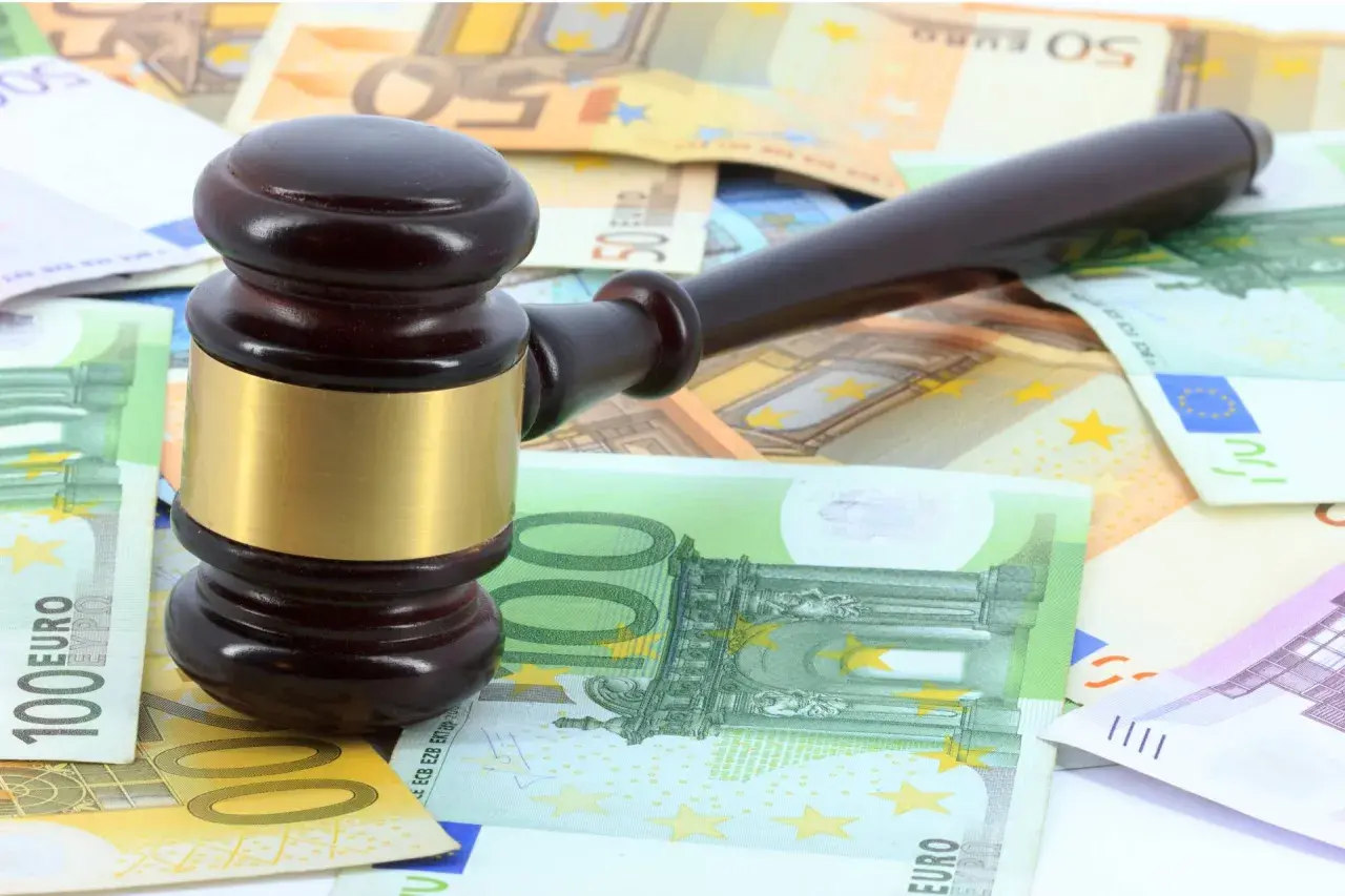 Martillo de juez sobre billetes de euros, simbolizando los gastos de notaría en una compraventa de vivienda.