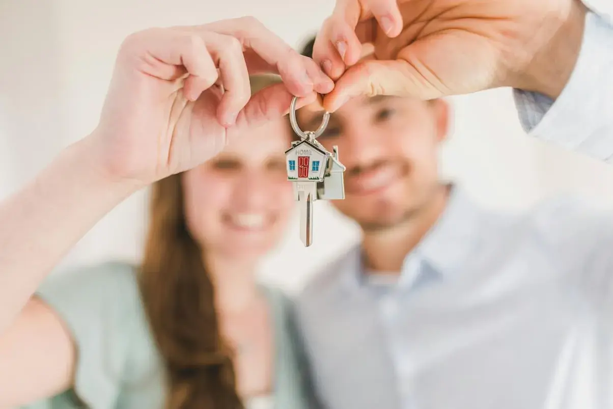 Pareja feliz sosteniendo llaves de casa. ¿Cuánto cobra Tecnocasa por vender un piso?