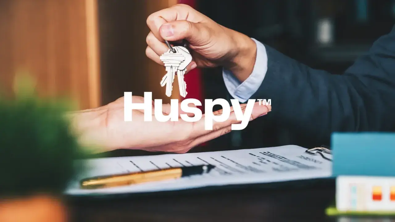 Manos intercambiando llaves sobre un contrato. Las opiniones sobre Huspy son positivas, facilitando transacciones inmobiliarias.